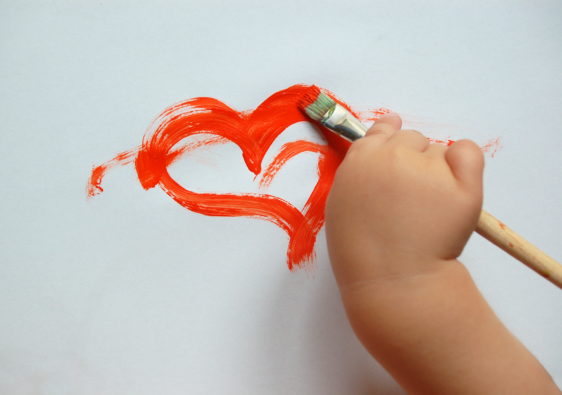 Foto von einer Kinderhand, die ein Herz malt, als Symbol für die freie Entfaltung, welche öffnetliche Lernorte versprechen