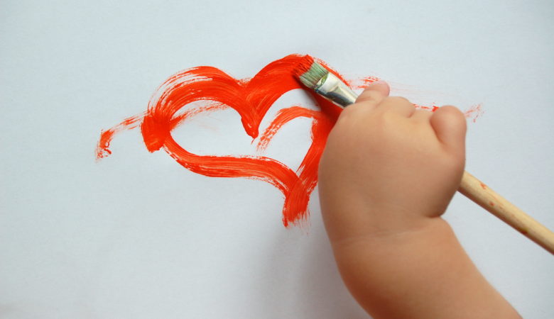 Foto von einer Kinderhand, die ein Herz malt, als Symbol für die freie Entfaltung, welche öffnetliche Lernorte versprechen