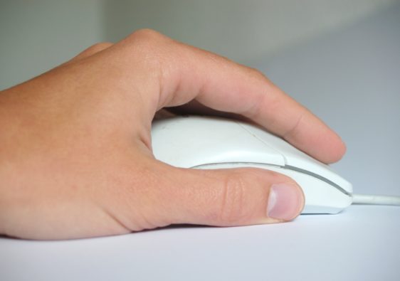 Foto von einer Hand mit einer Computermaus als Symbolbild für die Medienkompetenz
