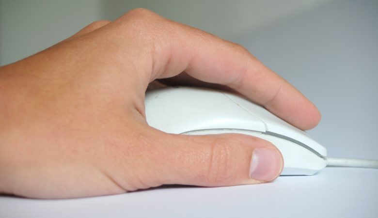Foto von einer Hand mit einer Computermaus als Symbolbild für die Medienkompetenz