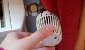 Foto von einer Hand am Heizungsregler