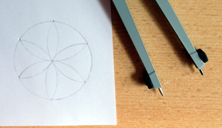 Foto von einem Zirkel und einer kleinen Zeichnung, die mit dem Zirkel entstanden ist