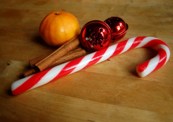 Foto von einer Zuckerstange, einer Zimtstange und einer Clementine passend zu Weihnachten