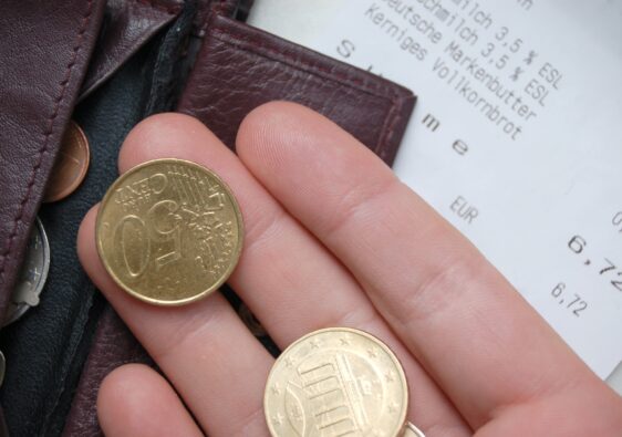 Einkaufen will gelernt sein: Das Foto zeigt einen Kassenbon sowie eine Hand mit Kleingeld
