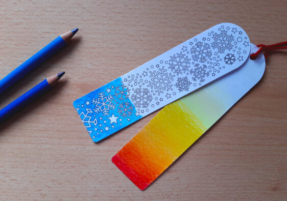 Foto von einem Schreibtisch auf dem Buntstifte und zwei Lesezeichen liegen